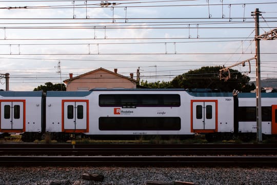 Barcelona skyline with railway tracks in the foreground, symbolising the R1 Rodalies line transfer discussions between the Catalan and Spanish governments.